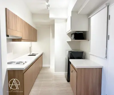 a kitchen with wooden cabinets and a counter top at Casa Escudero in Manila