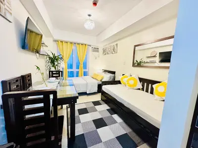 a room with two beds and a table in it at The 23rd Haven by Kasara Urban Resort Residences in Manila