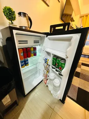 an open refrigerator filled with lots of food and drinks at The 23rd Haven by Kasara Urban Resort Residences in Manila