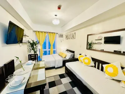 a living room with two beds and a dining room at The 23rd Haven by Kasara Urban Resort Residences in Manila