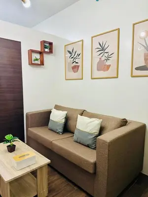 a living room with a brown couch and a table at Mon ciel suite Spacious 1BR Air Residence SMDC in Manila