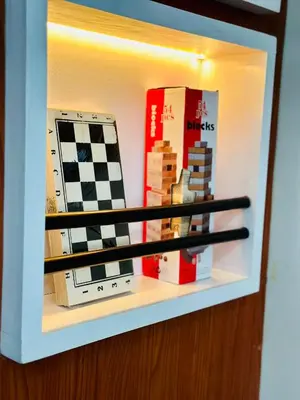 a shelf with books and a chessboard on it at Mon ciel suite Spacious 1BR Air Residence SMDC in Manila