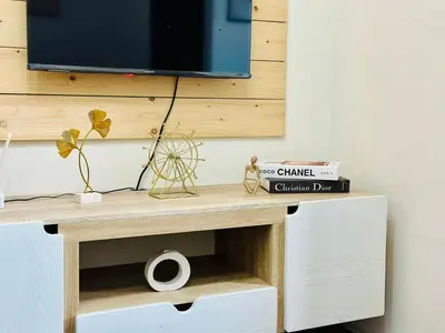 a wooden table with a tv on a wall at Mon ciel suite Spacious 1BR Air Residence SMDC in Manila