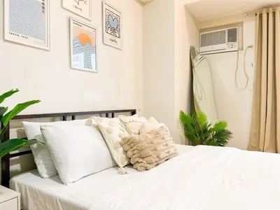 a bedroom with a white bed with white pillows at Luxury BGC Condo, Venice Grand Canal #vlrtc5h in Manila
