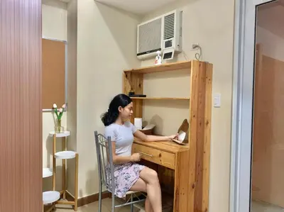 a woman sitting at a desk with a laptop at Elegant Condo Beside Venice Grand Canal #vlra23j in Manila
