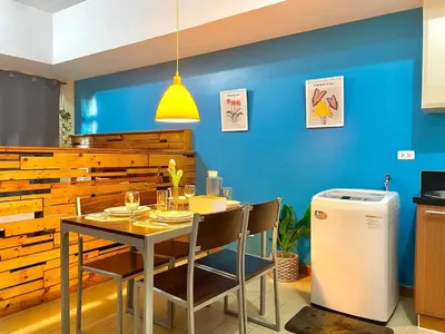 a dining room with a table and a blue wall at Elegant Condo Beside Venice Grand Canal #vlra23j in Manila