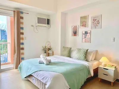 a bedroom with a large bed and a window at Luxury Bgc Condo Near Venice Mall #vlra22e in Manila