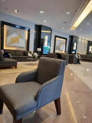a living room with a blue chair in a lobby at SMDC Fame Marcelle's Place near Mega Mall in Manila