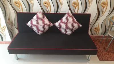 two pillows are sitting on a black couch at SMDC Fame Marcelle's Place near Mega Mall in Manila