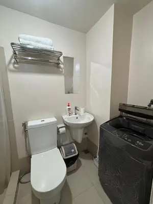 a bathroom with a white toilet and a sink at Condo in Silang Fullerton Suites - near tagaytay and nuvali in Silang