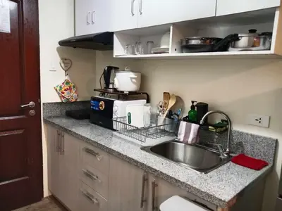 a kitchen counter with a sink and a microwave at Condo in Silang Fullerton Suites - near tagaytay and nuvali in Silang