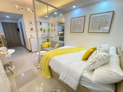 a bedroom with a large bed with a yellow blanket at 1BR w/ Balcony near Megamall: The Admiral‘s Lounge in Manila