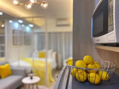a bowl of fruit on a counter with a microwave at 1BR w/ Balcony near Megamall: The Admiral‘s Lounge in Manila