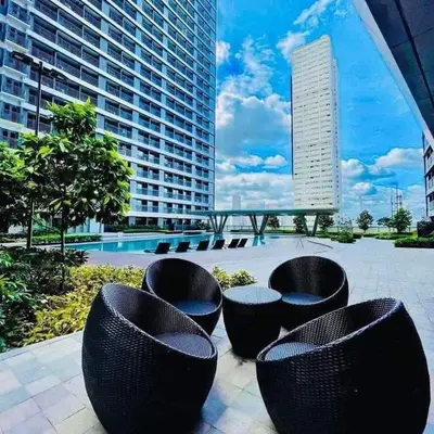 a patio with black chairs and a large building at 1BR w/ Balcony near Megamall: The Admiral‘s Lounge in Manila