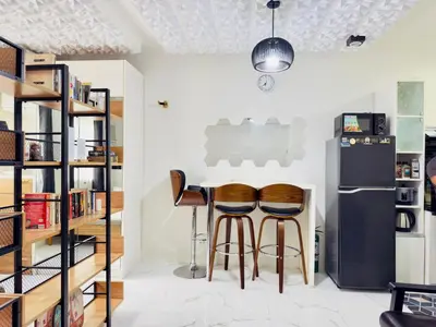 a kitchen with two bar stools and a refrigerator at Modern Simplicity: Cozy @Nuvali in Pitland