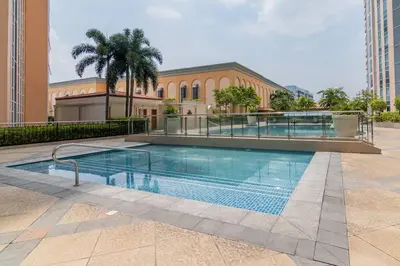 a large swimming pool in front of a building at Studio at Venice Mall, near Airport, BGC & Makati in Manila