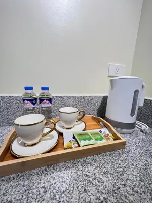 a tray with two cups and water bottles on a counter at Condo near Nuvali Laguna Technopark St Benedict Church in Bayabasan