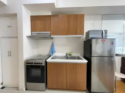 a small kitchen with a sink and a refrigerator at 8 Adriatico in Manila