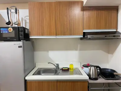 a small kitchen with a sink and a refrigerator at 8 Adriatico in Manila