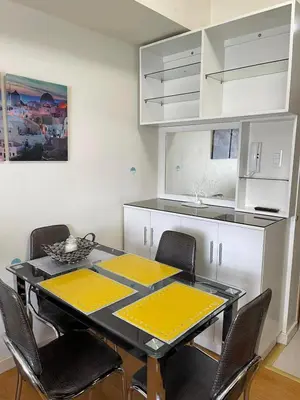 a dining room with a table and chairs in a kitchen at 8 Adriatico in Manila