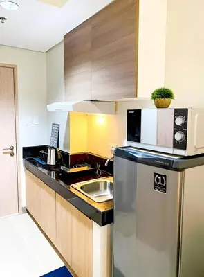 a kitchen with a sink and a refrigerator at Casa Aria at SMDC Charm Residences - No Parking in Manila