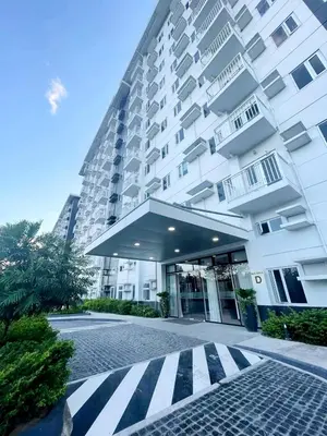 a large white building with a crosswalk in front of it at Casa Aria at SMDC Charm Residences - No Parking in Manila