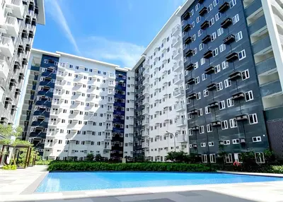 an apartment building with a swimming pool in front of it at Casa Aria at SMDC Charm Residences - No Parking in Manila