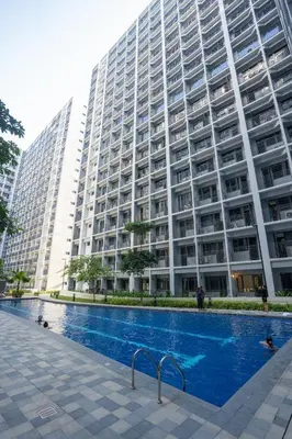 a large building with a swimming pool in front of it at Concrete Palms near MOA w/ awesome view of Manila in Manila