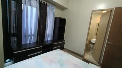 a bedroom with a bed and a window and a mirror at 1 bedroom Condotel near Terminal3 Airport in Manila