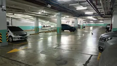 a parking garage with cars parked in it at 1 bedroom Condotel near Terminal3 Airport in Manila