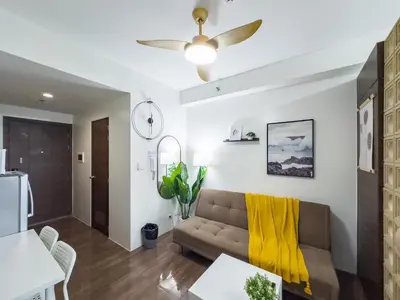 a living room with a couch and a ceiling fan at GemstoneBR in SMDC Air Residences in Manila