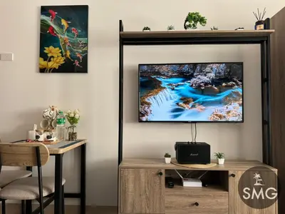 a living room with a flat screen tv on a wall at SMG - Studio@Green2: Wi-fi, Netflix, Swim & Relax in Cavite