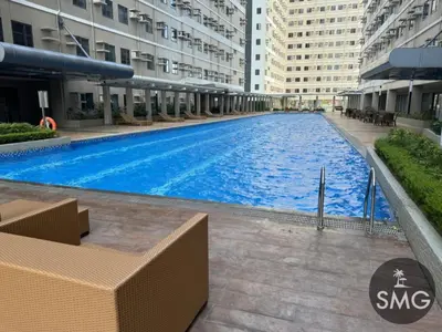 a large swimming pool in the middle of a building at SMG - Studio@Green2: Wi-fi, Netflix, Swim & Relax in Cavite