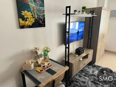 a living room with a table and a tv at SMG - Studio@Green2: Wi-fi, Netflix, Swim & Relax in Cavite