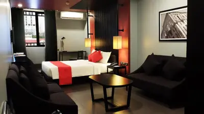 a hotel room with a bed and a couch at Amelie Hotel Manila in Manila