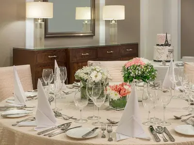 a table with wine glasses and flowers on it at Discovery Primea in Manila