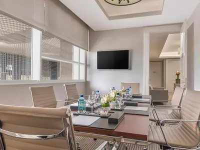 a dining room with a table and chairs and a television at Discovery Primea in Manila