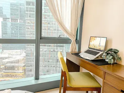 a laptop computer sitting on a desk in front of a window at BGC 1BR Condo Steps from Grand Hyatt #ournw18l in Manila