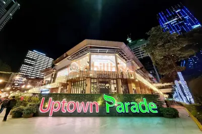 a downtown paradise sign in front of a building at night at BGC 1BR Condo Steps from Grand Hyatt #ournw18l in Manila