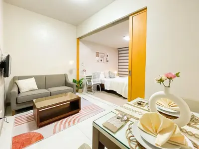 a living room with a couch and a table at Cozy Bgc Stay Near Uptown Mall & Hyatt #ournw24l in Manila