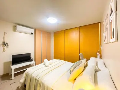 a bedroom with a large white bed with yellow pillows at Cozy Bgc Stay Near Uptown Mall & Hyatt #ournw24l in Manila