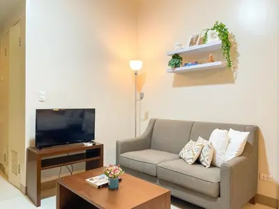 a living room with a couch and a tv at Premium Bgc Staycation, Uptown Area #ournw27b in Manila