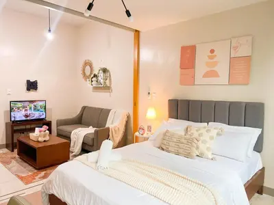 a bedroom with a bed and a chair and a television at Bgc Condo Near Uptown Mall, Grand Hyatt #ournw25b in Manila