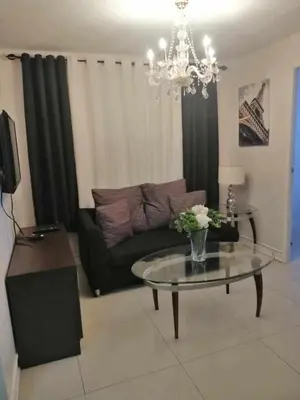 a living room with a couch and a glass table at Romantic 2BR Condo unit with free WiFi in Anabu Primero