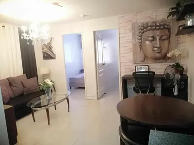 a living room with a couch and a table at Romantic 2BR Condo unit with free WiFi in Anabu Primero