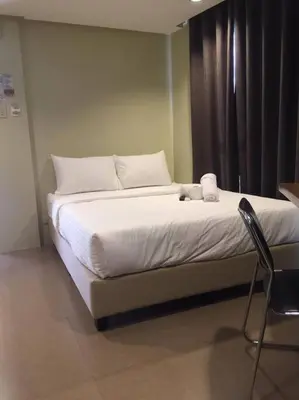 a bed with white sheets and pillows in a room at Spacious Studio Apartment B203 in Manila