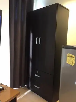 a black cabinet with three drawers and a refrigerator at Spacious Studio Apartment B203 in Manila
