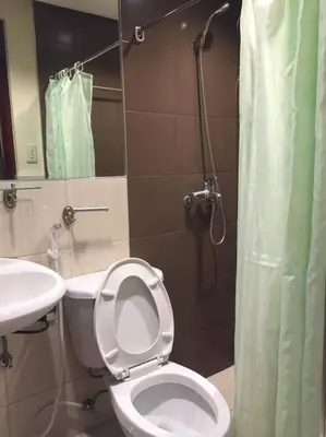 a bathroom with a toilet and a sink and a shower at Spacious Studio Apartment B203 in Manila