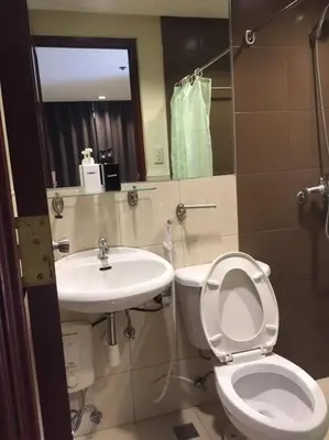 a bathroom with a toilet and a sink at Spacious Studio Apartment B203 in Manila