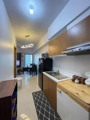 a kitchen with a sink and a refrigerator at Staycation near SLMEC, US Embassy and Supreme Court in Manila